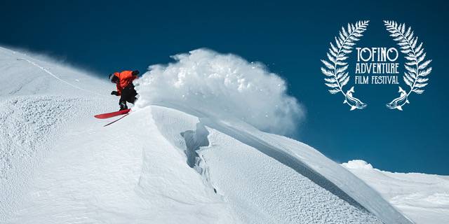 Snowboarder kicking up white powder on a blue sky day. with Tofino Adventure Film Festival logo